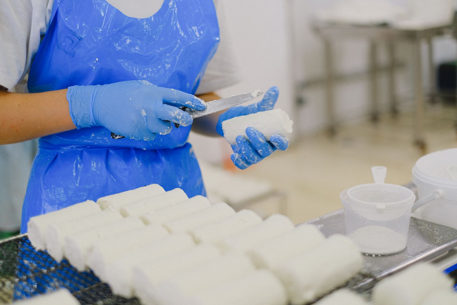 Personal con guantes y uniforme manipulando alimentos en planta