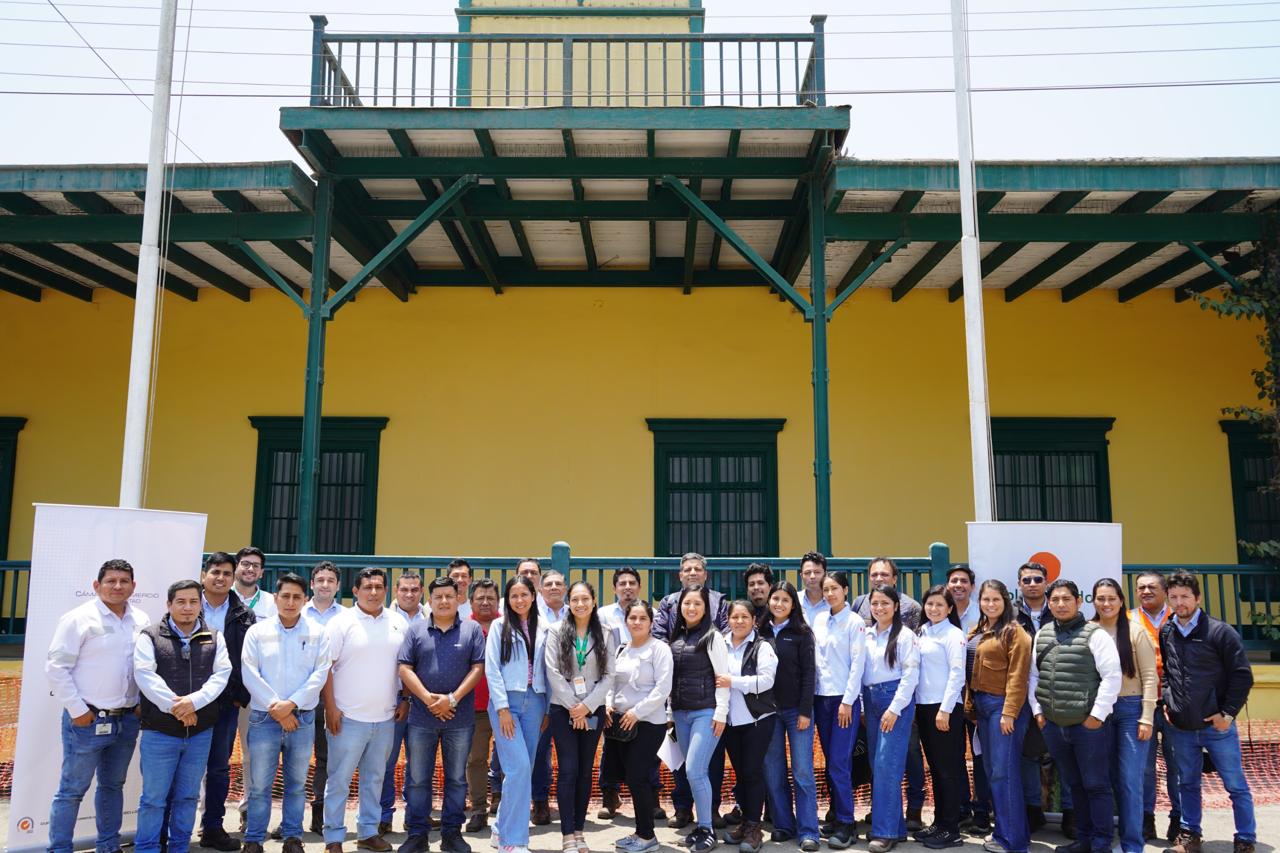 Grupo de participantes de una capacitación de Proinocuidad frente a una casona amarilla